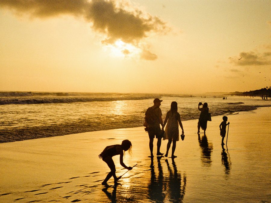 A family walking together on the beach at sunset
