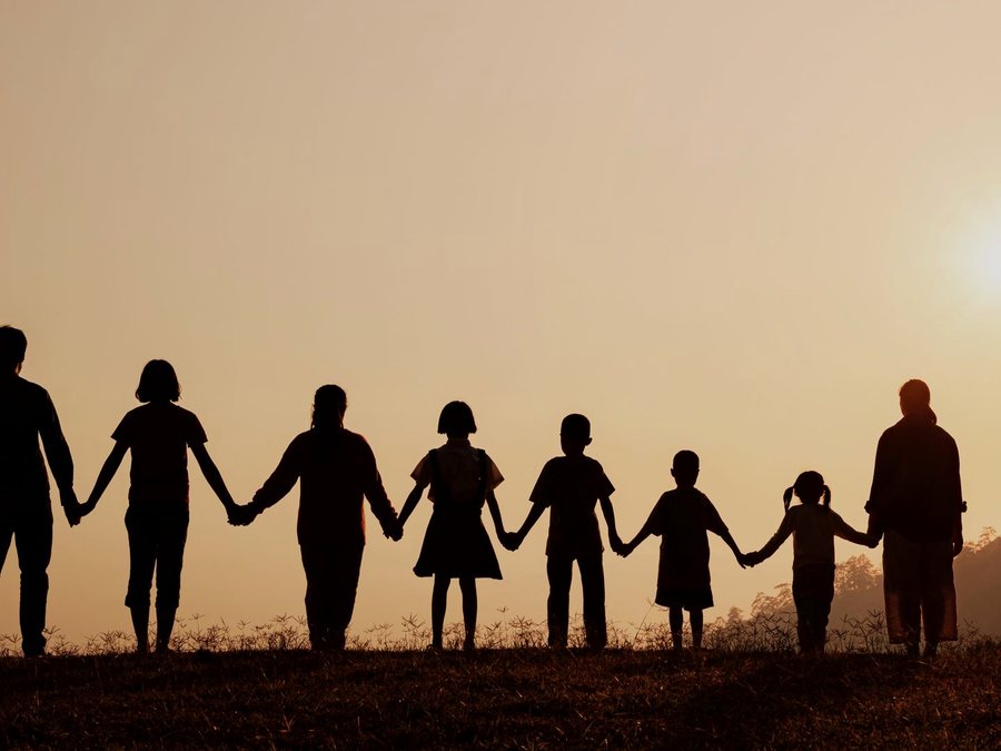 A family silhouetted against the sunset, walking together