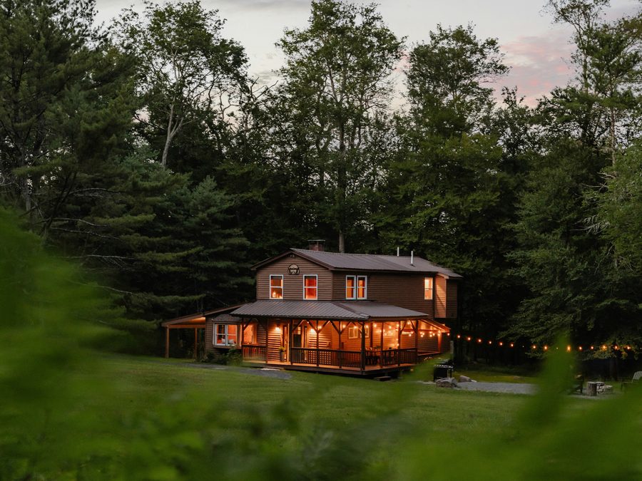 A family home at dusk with the porch lights on