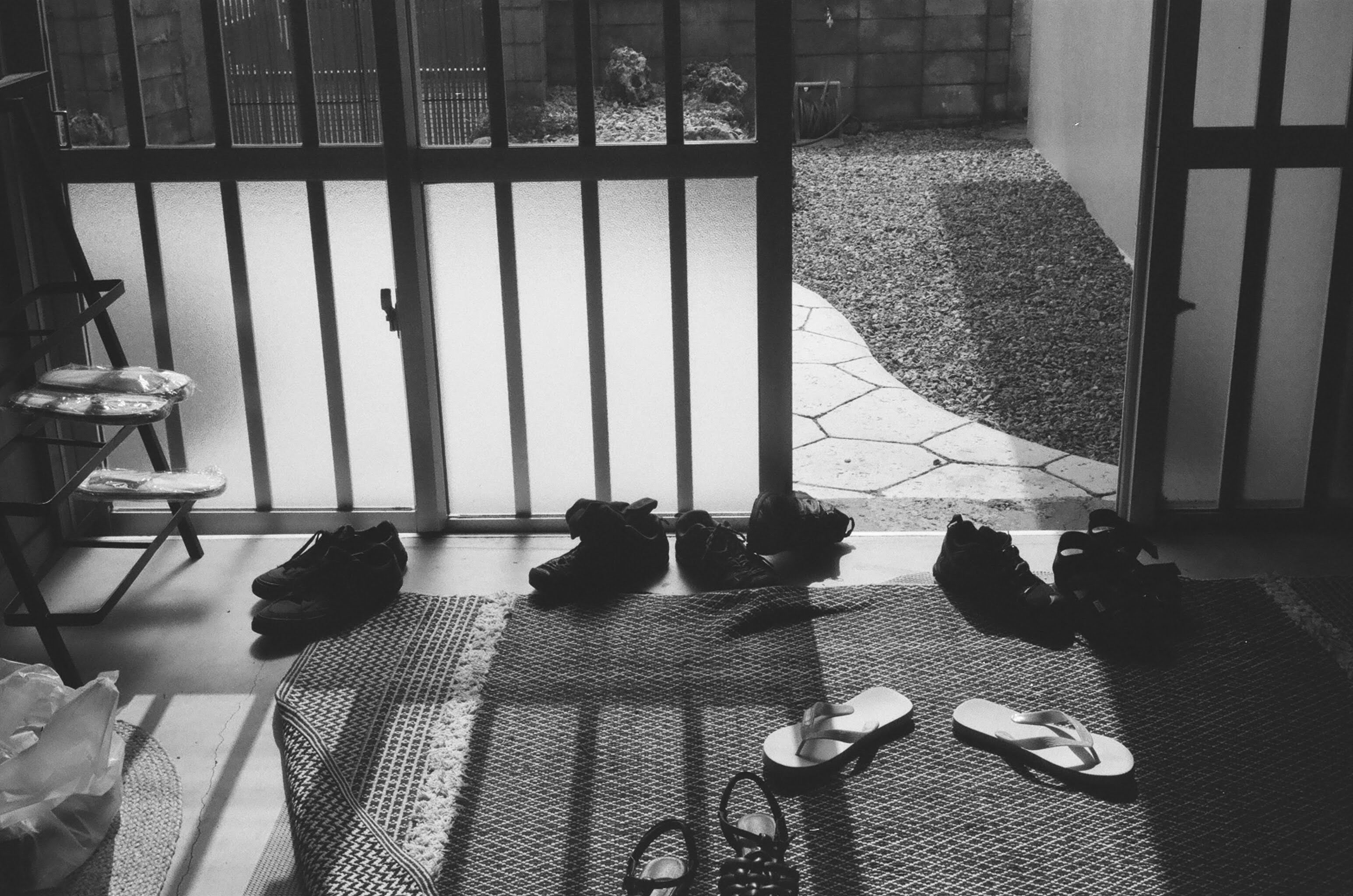A black-and-white home entryway with shoes arranged by the walkway